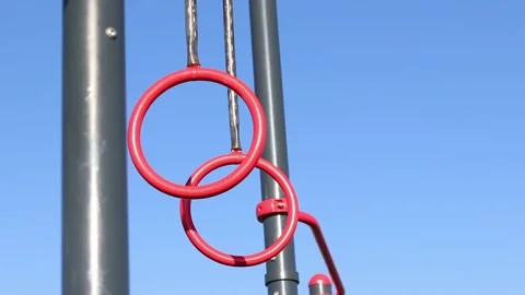 Red pull-up rings on the sky background Stock Footage 332169261