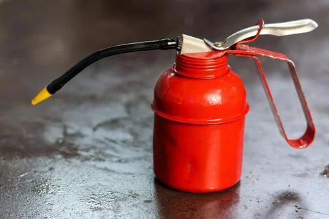Red Pump Oil Can on Workshop Workbench. Stock Photos