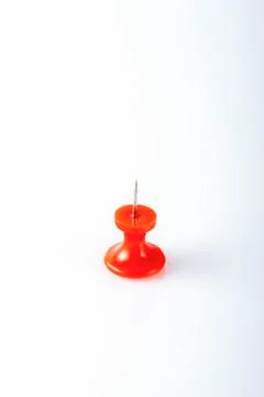Red push pin on white background. Close-up. Stock Photos