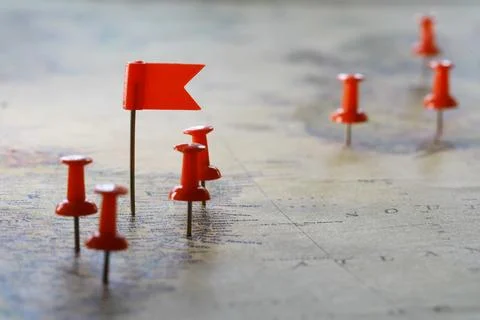Red Push Pins and Flag Markers on a World Map Highlighting Travel Destination Stock Photos