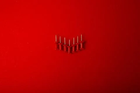 Red pushpin on a red background, monochrome Stock Photos