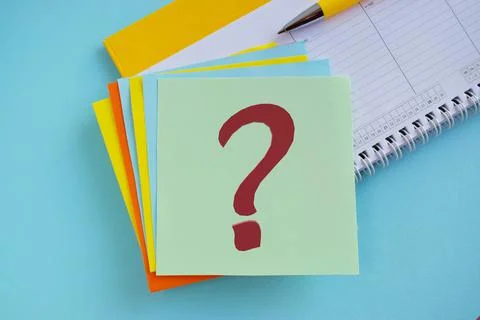 Red question mark on colorful note, bright blue background Stock Photos