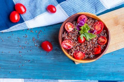 Red quinoa salad with tomato on a rustic table. Superfood and healthy eating  Stock Photos