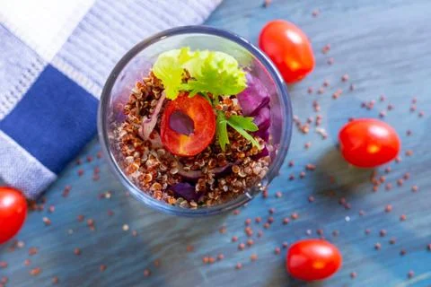 Red quinoa salad with tomato on a rustic table. Superfood and healthy eating  Stock Photos