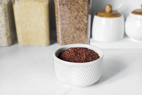 Red quinoa on the white plate on the background of a modern kitchen Stock Photos