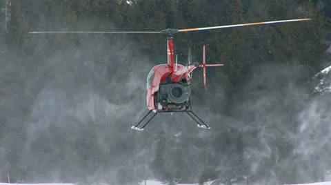 Red R22 Chopper Hovering over Blowing Snow Stock Footage 10841214
