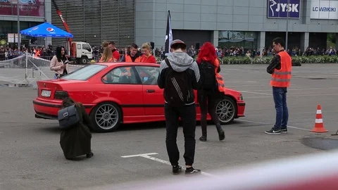 Red racing car start a drift race. A lot of people around. Stock Footage 107828629