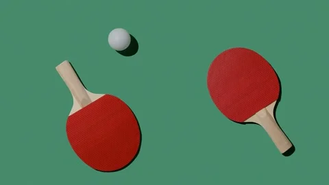 Red rackets and a white ball move on a green tennis table. Stock Footage 220614301