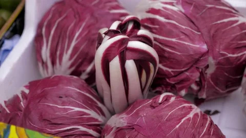 Red radicchio are placed in a container at a market stall Video stock 186551457