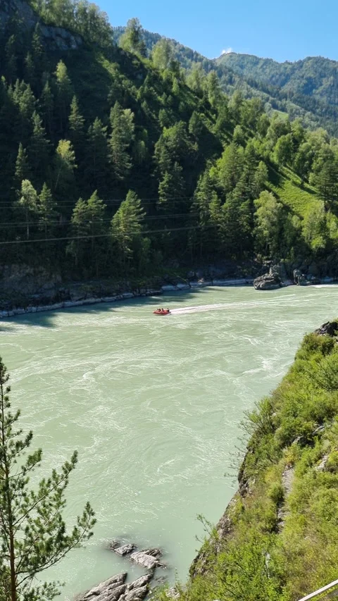 Red raft navigating katun river in Altai mountains, Russia, with tourists Stock Footage 315066778