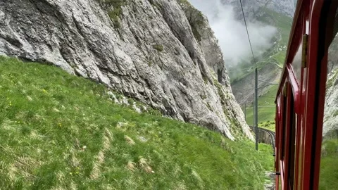 Red railcar on the way to the top of Mount Pilatus, Alpnachstad, Switzerland Stock Footage 136574034