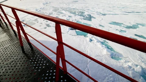 Red-railed ship deck overlooks sprawling polar sea ice with turquoise melt ponds Stock Footage 318292510