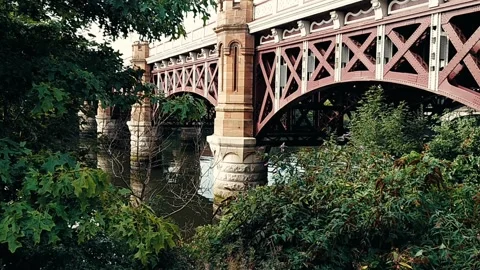 A red railway bridge with a river flowing under it Video stock 160437149