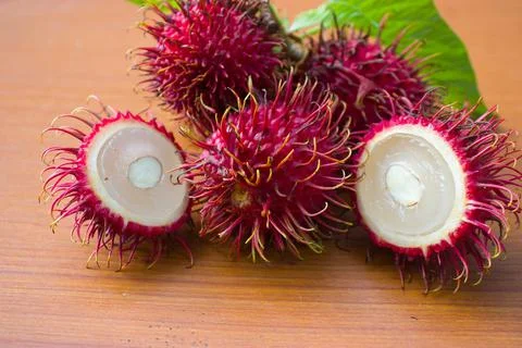 Red rambutan on a brown table background Stock Photos