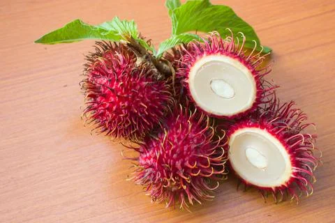 Red rambutan on a brown table background Stock Photos