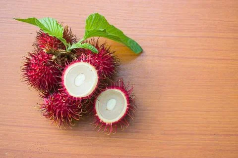 Red rambutan on a brown table background Stock Photos