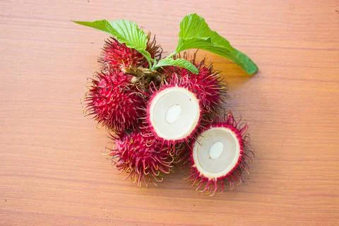 Red rambutan on a brown table background Stock Photos