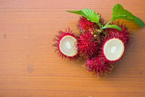 Red rambutan on a brown table background Stock Photos
