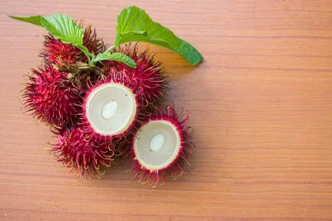 Red rambutan on a brown table background Stock Photos