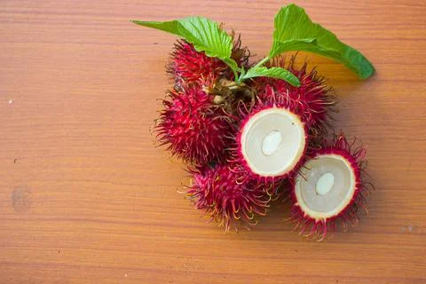 Red rambutan on a brown table background Stock Photos