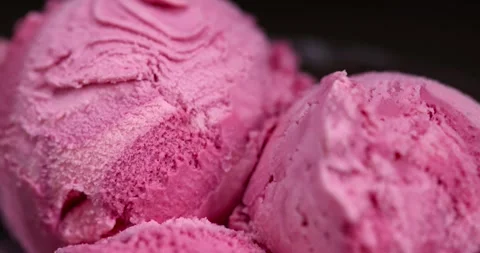 Red raspberry ice cream in a glass bowl on a black background, delicious sweet Stock Footage 297587603