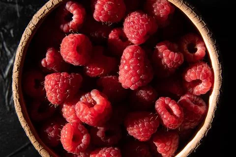 Red raspberry in a plate on a dark background. Fruit berries background. View Stock Photos