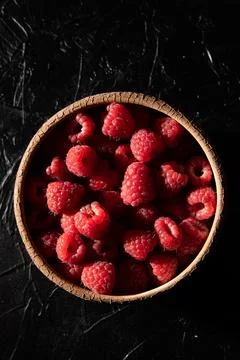 Red raspberry in a plate on a dark background. Fruit berries background. View Stock Photos
