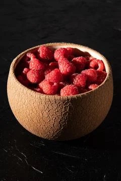 Red raspberry in a plate on a dark background. Fruit berries background. Summ Stock Photos