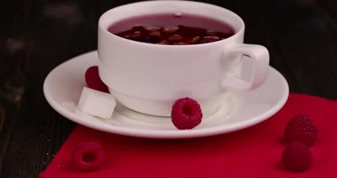 Red raspberry tea with pieces of fruit and berries Stock Footage 212322149