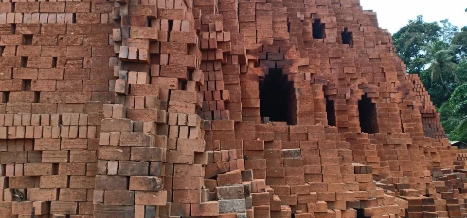 Red raw bricks stack in a row , coconut trees Stock Photos