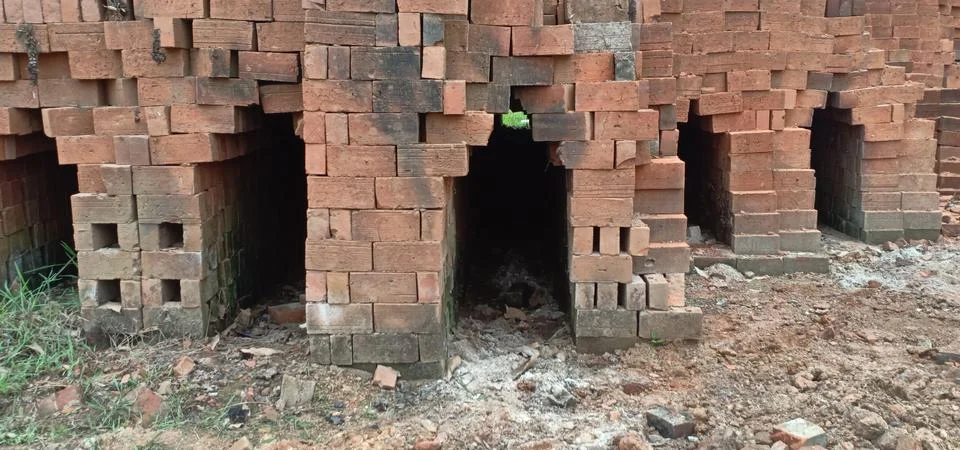 Red raw bricks stack in a row , coconut trees 스톡 사진