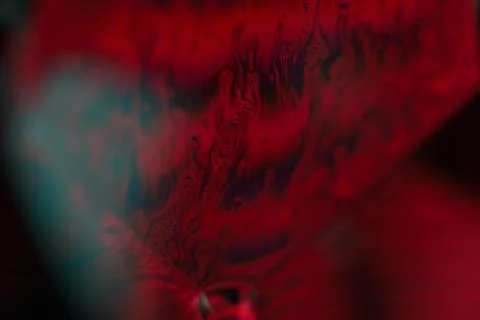 Red reflections of liquid in macro, red surface Stock Photos