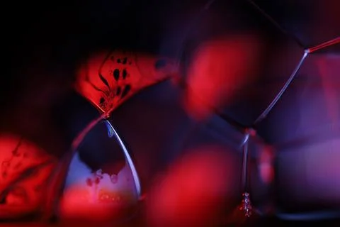 Red reflections of liquid in macro, red surface Stock Photos