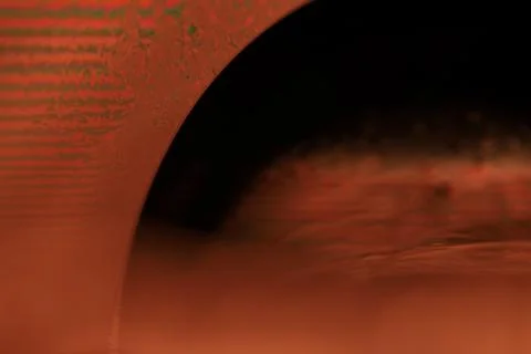 Red reflections of liquid in macro, red surface Stock Photos