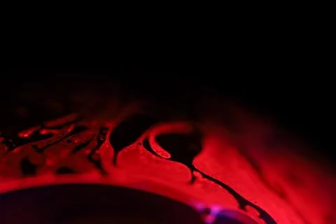 Red reflections of liquid in macro, red geometric shapes Stock Photos