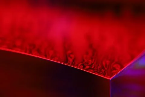 Red reflections of liquid in macro, red geometric shapes Stock Photos