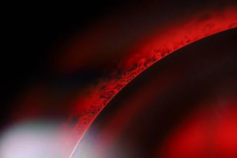 Red reflections of liquid in macro, red surface Stock Photos