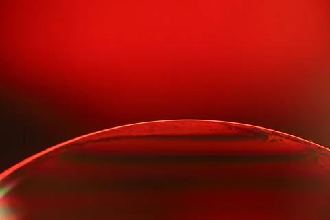 Red reflections of liquid in macro, red surface Stock Photos