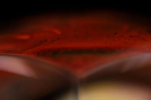 Red reflections of liquid in macro, red surface Stock Photos