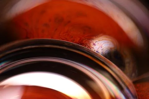 Red reflections of liquid in macro, red surface Stock Photos