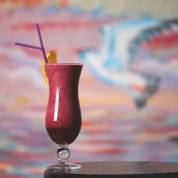 Red refreshing drink. Cold beverage in long glass goblet with orange slice and Stock Photos