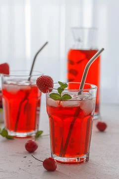 Red refreshing drink with mint on a gray background. Stock Photos