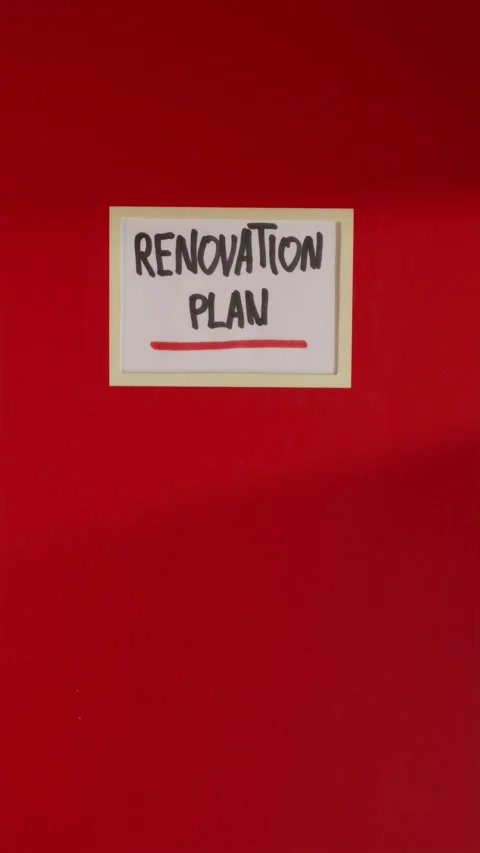Red Renovation Plan notebook folder on wooden tabletop Stock Footage 341245986