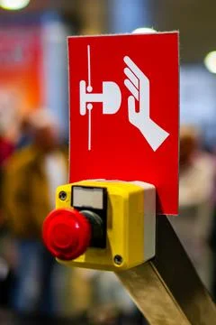 Red Reset button on the wall. red emergency stop switch button in a factory Stock Photos