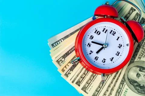 Red retro styled alarm clock on heap of american dollars. Stock Photos