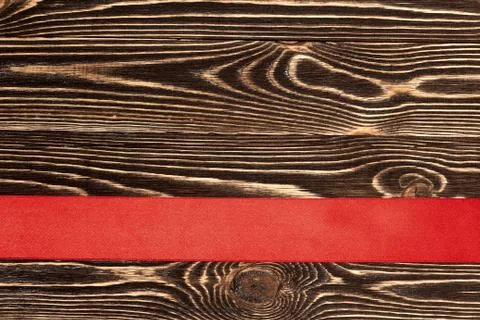 Red ribbon and wooden background Stock Photos