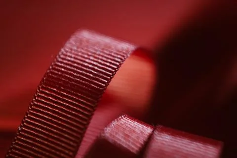 Red ribbon on red table background. Flat lay Stock Photos