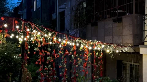 Red ribbon of string lights of decorative cafe restaurant in outdoor nightlife Stock Footage 338348314