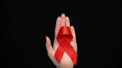 Red ribbon on woman's hand support for World aids day. Video stock 142932913