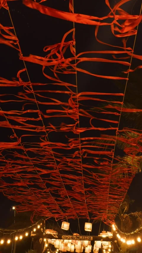 Red ribbons and paper lanterns creating a festive ceiling decoration at an Stock Footage 332790310